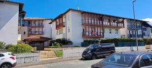 parking z samochodami zaparkowanymi przed budynkiem w obiekcie Appartement lumineux T3 avec jardin privatif à Hendaye - Parking et wif gratuit w mieście Hendaye