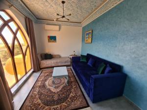 a living room with a blue couch and a table at Mahdia - Baghdadi - Laourient Apartments, restaurant, café in Mahdia
