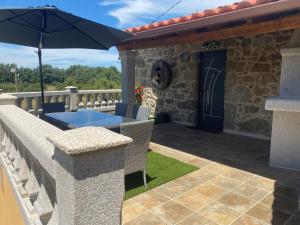 une terrasse avec une table et un parasol dans l'établissement As Penedas, Casa dos Arcos, à Sober