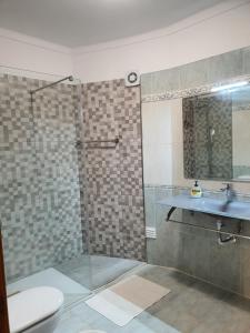 un bagno con doccia, lavandino e WC di Apartamento Sol e Mar Sesimbra a Sesimbra Altre 16 foto