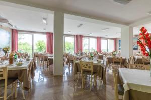 a dining room with tables and chairs and windows at Hotel Silver in Milano Marittima +48 photos