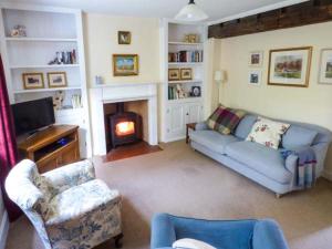 a living room with a couch and a fireplace at Woodside Cottage in Snainton