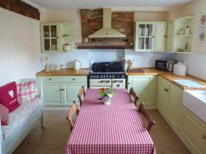 a kitchen with a table with a red and white checkered table cloth at Woodside Cottage in Snainton