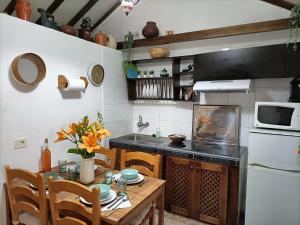 uma pequena cozinha com uma mesa e um micro-ondas em Casa rural en el Parque Nacional de Garajonay en la Isla de La Gomera, Alonso y Carmen em Santa Cruz de Tenerife
