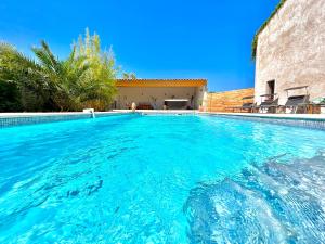 洛爾格的住宿－Studio avec jacuzzi et piscine，一座房子前面的蓝色海水游泳池