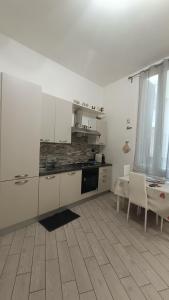 a kitchen with white cabinets and a table and a window at Il filo di Claudia in Savona
