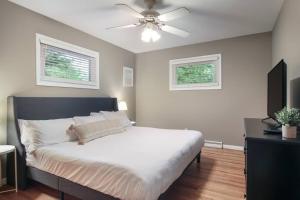 a bedroom with a large bed with a ceiling fan at 3 min to Beach, Game Room, Hot tub & Firepit in Traverse City