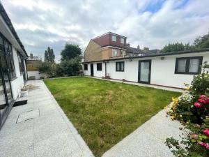 a backyard of a house with a green yard at 371 Cranbrook Rd IG2 in Ilford