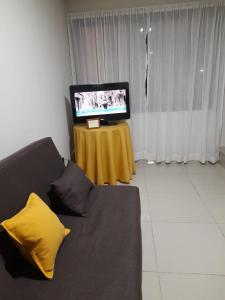 uma sala de estar com um sofá e uma televisão em Arecas em Villa Carlos Paz