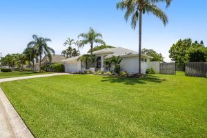 a house with a large yard with palm trees at Vacation Station in Bradenton