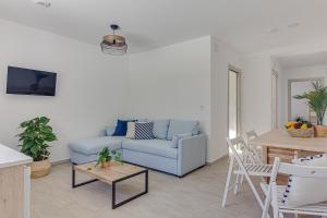 a living room with a blue couch and a table at Apartamentos Playa de Finisterre in Fisterra