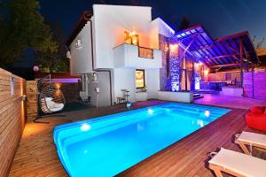 a swimming pool in front of a house at night at Nibras Villa Resort Hotel in Sapanca