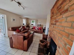 a living room with couches and a brick fireplace at Holly Lodge in Norwich