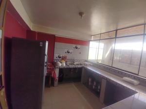 cocina con paredes rojas y nevera negra en BACKPAKERS MIRADOR, en Huaraz