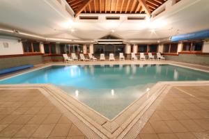 a large swimming pool with chairs in a building at Residenza Del Sole in Gressoney-Saint-Jean