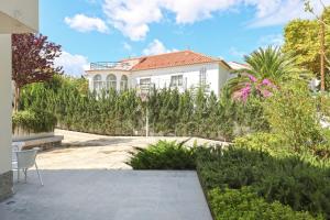 une maison blanche avec un jardin en face dans l'établissement Santa Joana Villa, à Lisbonne