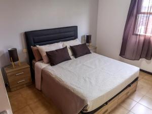 a bedroom with a large bed with a black headboard at Atlantic Dawn in Los Cancajos