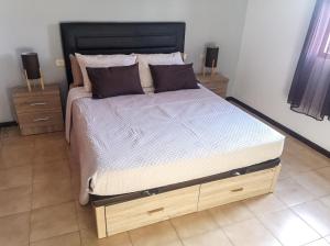 a bedroom with a large bed with a black headboard at Atlantic Dawn in Los Cancajos