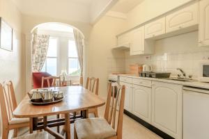 una cucina con tavolo in legno e una sala da pranzo di Clooneavin Apartment 6 a Lynmouth