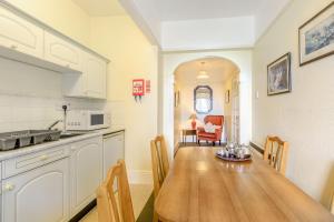 una cucina e una sala da pranzo con tavolo in legno di Clooneavin Apartment 6 a Lynmouth