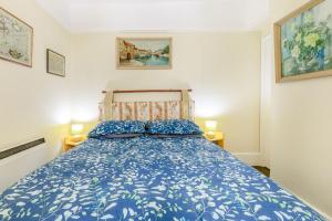 a bedroom with a bed with a blue bedspread at Clooneavin Apartment 6 in Lynmouth