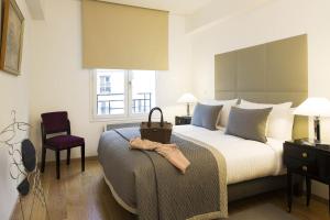 a bedroom with a bed and a chair and a window at Montmartre Residence in Paris +94 photos