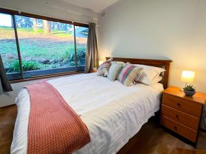 a bedroom with a large bed with a window at The View, Metung in Metung