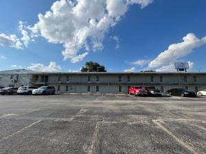 a building with cars parked in a parking lot at Mid Towne Inn & Suites in San Antonio