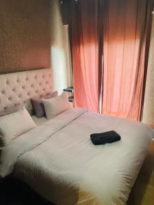 - un grand lit blanc avec un sac noir dans l'établissement Lovely 1BR apartment with free parking in gueliz, à Marrakech