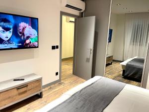 a bedroom with a bed and a flat screen tv on the wall at Mangio Dubrovnik Gold in Dubrovnik