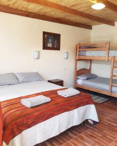 1 dormitorio con 1 cama y 2 literas en Hostal Ckamai, en San Pedro de Atacama