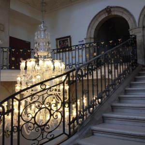 uma escadaria com um lustre num edifício em Hôtel de l'Abbaye des Prémontrés em Pont-à-Mousson