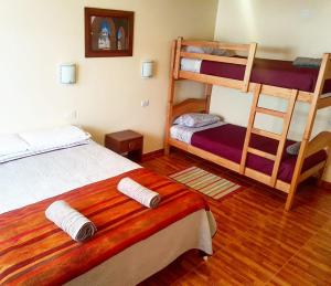 1 dormitorio con 2 literas y escalera en Hostal Ckamai, en San Pedro de Atacama