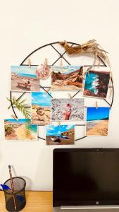 a collage of photos on a wall behind a computer monitor at Casa Armonía in Morro del Jable