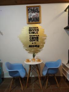 un tavolo con due sedie blu e un cartello sul muro di Acogedor Loft amueblado en el Centro de Tulancingo a Tulancingo