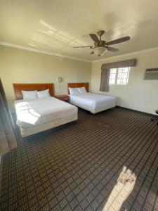 a bedroom with two beds and a ceiling fan at Viking Motel-Ventura in Ventura