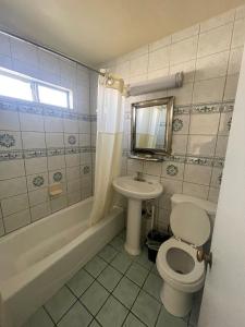 a bathroom with a toilet a sink and a bath tub at Viking Motel-Ventura in Ventura
