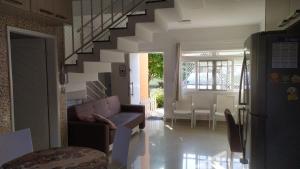 a living room with a couch and a staircase at Casa na Praia de Maitínga - Bertioga - SP in Bertioga