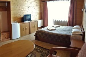 a hotel room with a bed and a television at Karpatski Zori Hotel in Bukovel