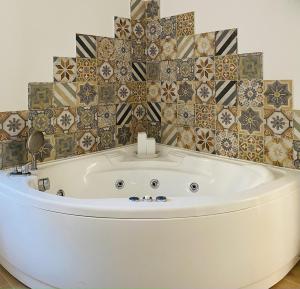 a bath tub in a bathroom with a tiled wall at Sogno Mediterraneo in Formia