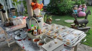 una mesa con comida y platos en un patio en Korp View House, en Wang Nam Khiao