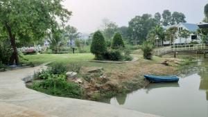 a blue boat is sitting in the water at Korp View House in Wang Nam Khieo