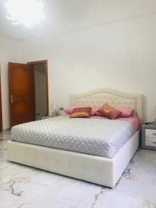 um quarto com uma cama branca com almofadas em CasaNella em Nardò