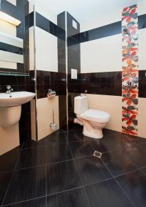 a bathroom with a toilet and a sink at Family Hotel Paros in Pomorie