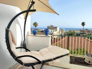 une chaise sur un balcon avec vue sur l'océan dans l'établissement Casa Tanna, à Donnalucata