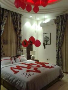 1 dormitorio con 1 cama grande decorada en rojo en شاليهات الرتز بلو, en Muhayil