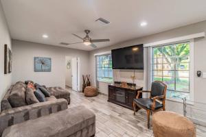 a living room with two couches and a flat screen tv at Bay Breeze Retreat plus 15 minutes from central TPA in Tampa