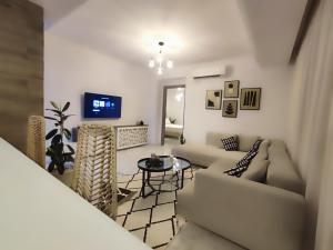 a living room with a couch and a table at Ideal Appart El Wahat VIP in El Aouina