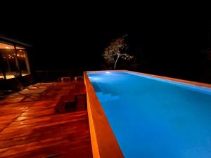 una piscina por la noche con luces azules en Cuatro Elementos Noh, en Tulum