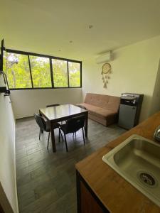 a kitchen and living room with a table and a couch at Tulum - Cuatro Elementos Noh - 2 habitación 6 huéspedes in Tulum